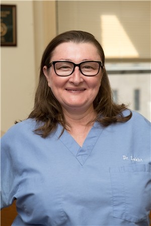 Dr. Anna Lekht, smiling, in blue scrubs